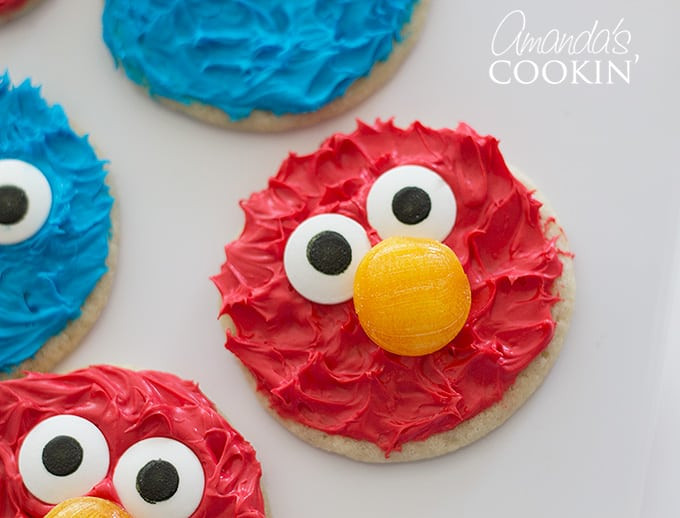Close-up of an Elmo cookie with textured red frosting and centered candy eyes, showcasing its simple yet effective design.