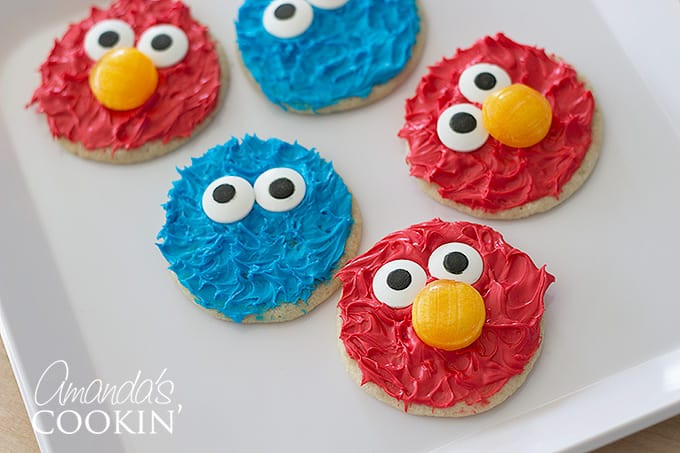 Elmo and Cookie Monster cookies displayed on a clean white table, highlighting their bright colors and playful designs.