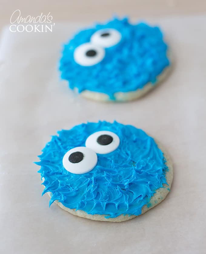 A Cookie Monster cookie with googly eyes placed slightly askew, giving him a cross-eyed look.