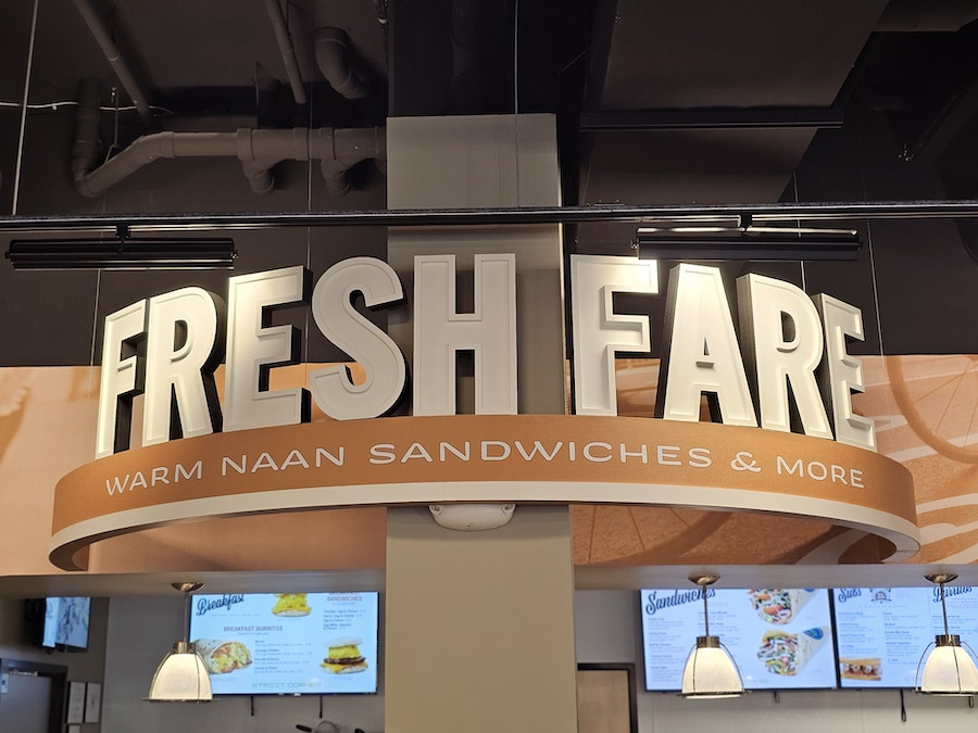 Fresh food counter and menu options at a Street Corner Urban Market, highlighting the quality and prepared meals available at your local street corner.