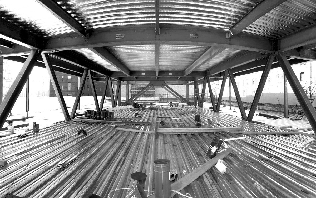 Workers operating machinery at the 520 West 20th Street construction site in New York, NY, during the building's development.