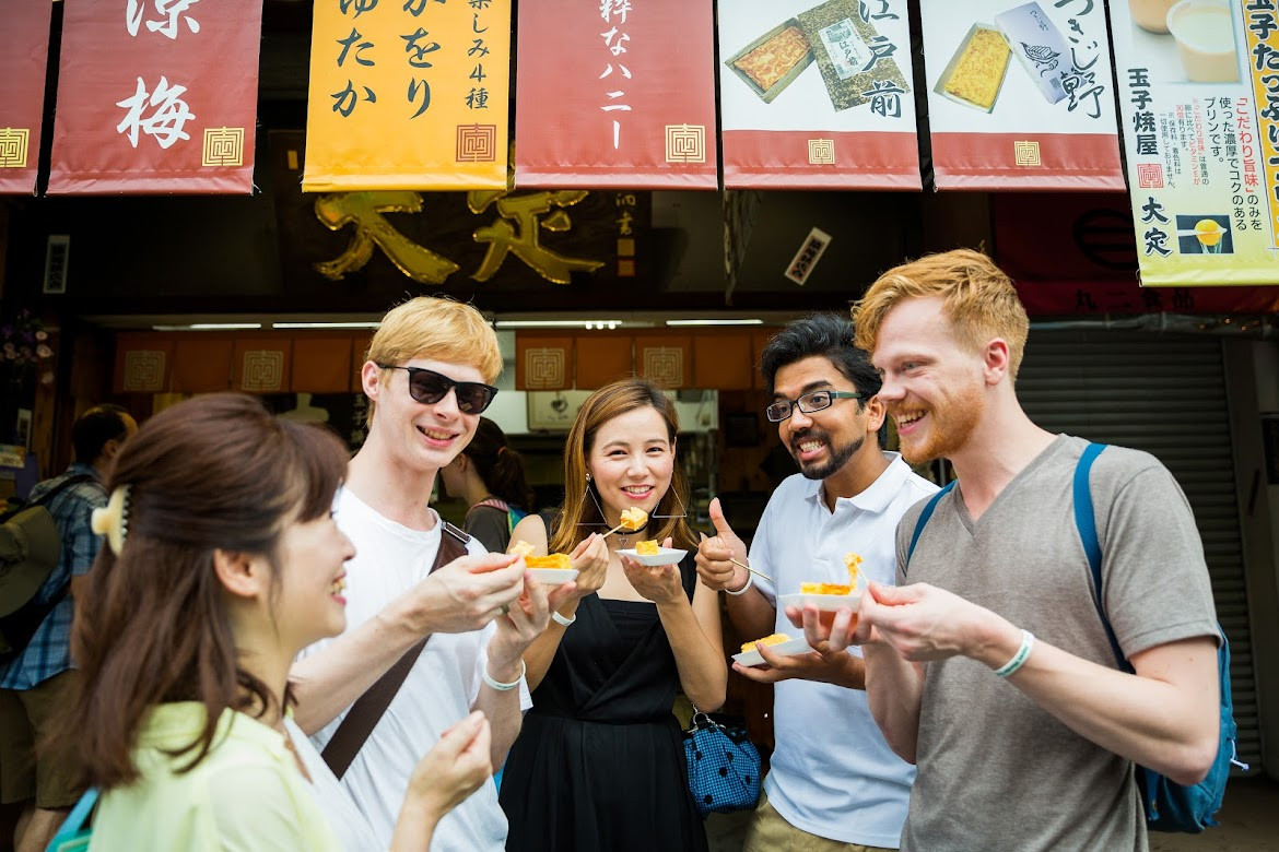 Tsukiji Fish Market tour group enjoying street food.