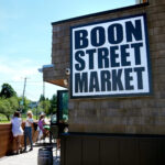 Exterior view of Boon Street Market in Narragansett, showcasing its revitalized historic building and outdoor seating area.