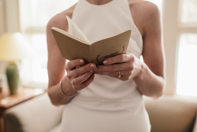 Elegant vow books and rings, capturing intimate wedding details before the King Street Brewing ceremony