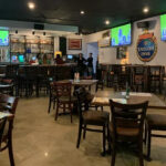 Inside Baker Street Pub showing bar area and TV screens, questioning its pub or sports bar identity