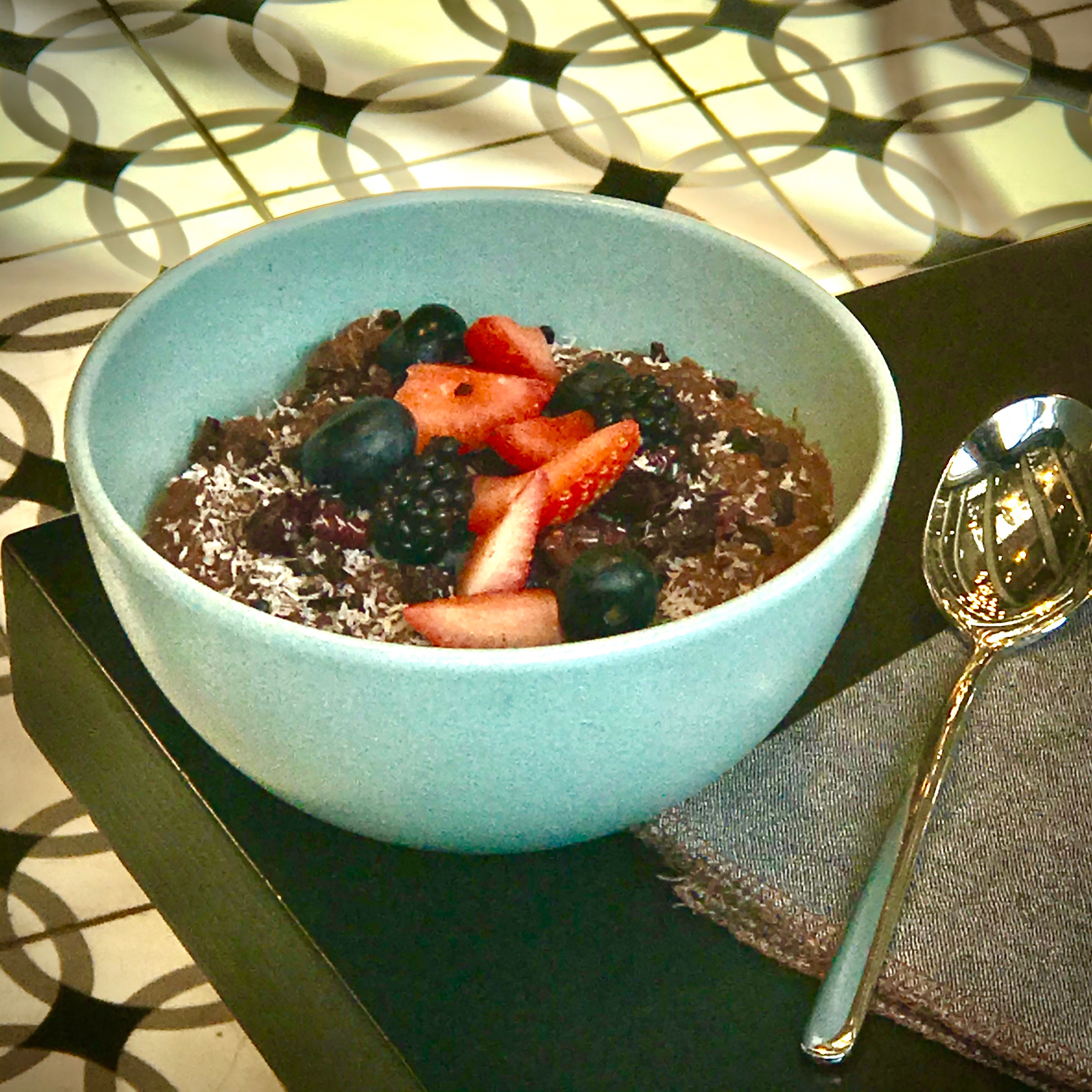 A bowl of warm porridge, a comforting and nutritious breakfast inspired by Danish hygge, created by Roman at Dandelion Chocolate's Bloom