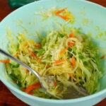 Close-up of shredded cabbage mixture with onion, green onion, carrot, and egg in a bowl, ready for Korean street toast.
