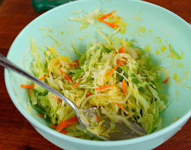 Close-up of shredded cabbage mixture with onion, green onion, carrot, and egg in a bowl, ready for Korean street toast.