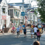 Vibrant storefronts and bustling pedestrian traffic on Commercial Street in Provincetown, Massachusetts.