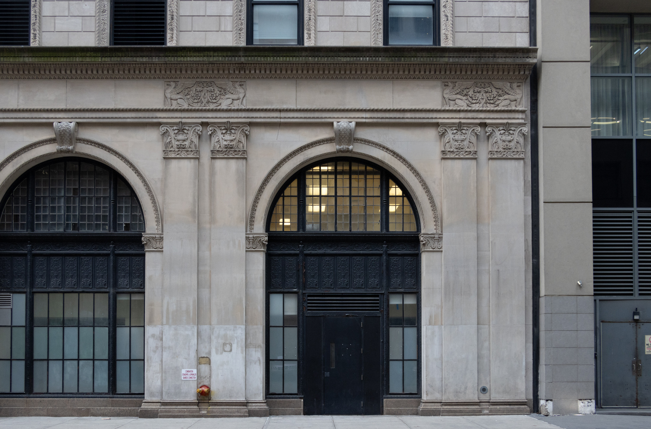 Arched doorways and pilasters on the Pearl Street facade of 345 Adams Street, highlighting the Renaissance Revival style of the landmarked Brooklyn Edison Building.