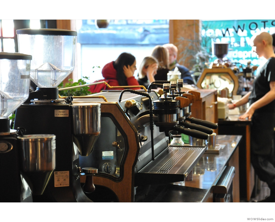 Close-up of the La Marzocco Strada espresso machines at Stumptown West 8th Street, emphasizing their polished stainless steel and the barista workspace.