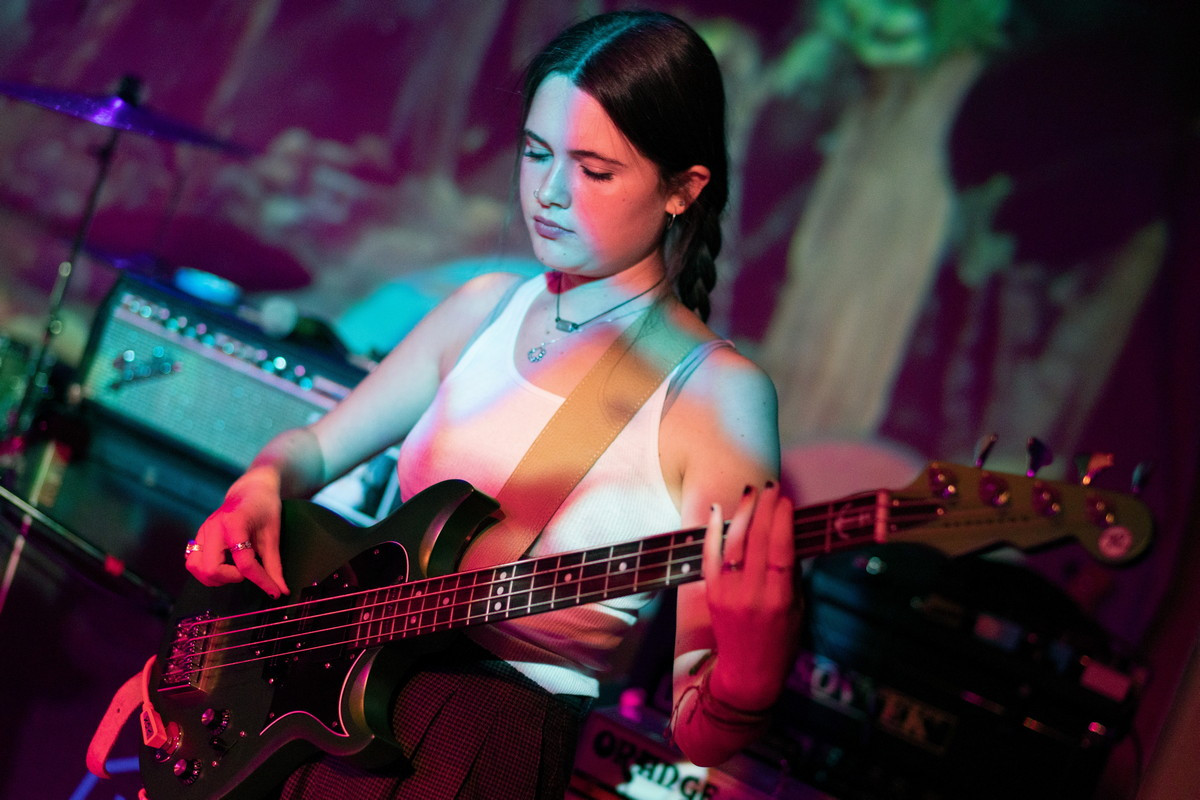 A dynamic shot of Hello Mary on stage at Bond Street Bar, showcasing their energetic performance and the intimate venue setting.