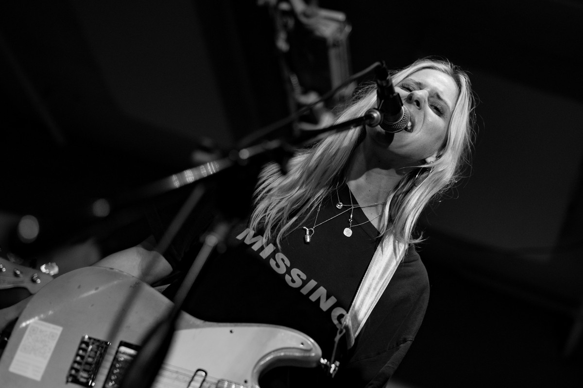 Alicia Bognanno of Bully performing live at Bond Street Bar, delivering a powerful vocal performance to an enthusiastic crowd.