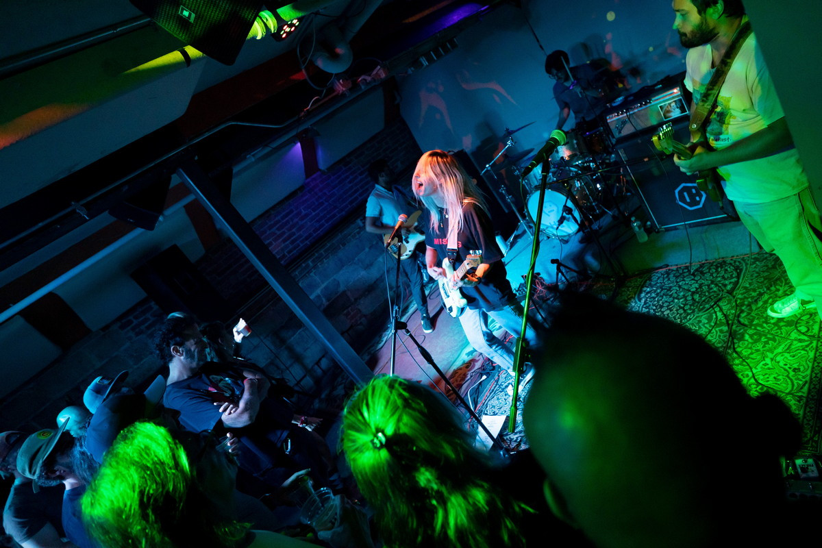 A fan's perspective photo from the Bully concert at Bond Street Bar, illustrating the close proximity to the stage and the band's engaging performance.