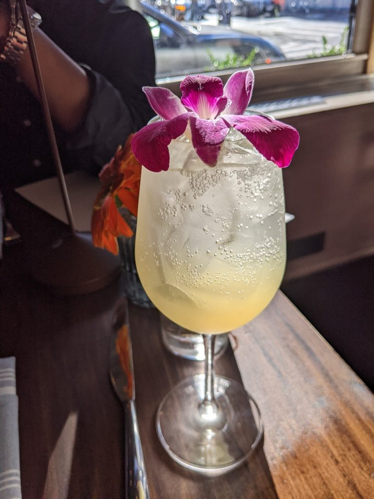 A glass of &quot;The Paula Special&quot; cocktail, elderflower liqueur topped with prosecco, garnished with a lemon twist.