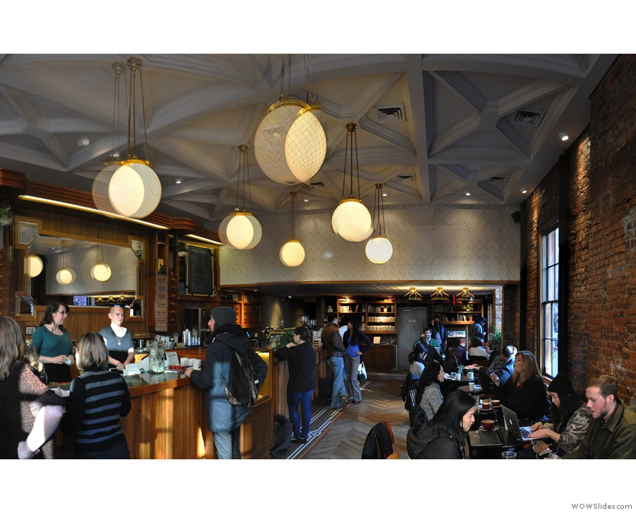 Interior of Stumptown West 8th Street's espresso bar, highlighting the counter, La Marzocco espresso machines, and available coffee merchandise.