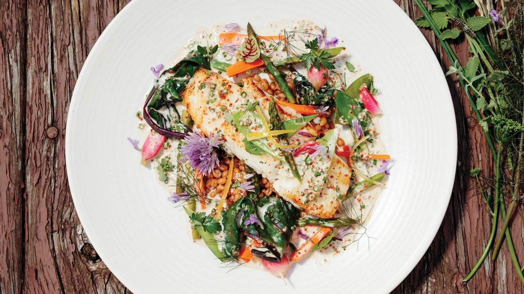 A close-up of a perfectly cooked fish dish at Cherry Street Cellar in Columbia Missouri, showcasing their land and sea menu concept.