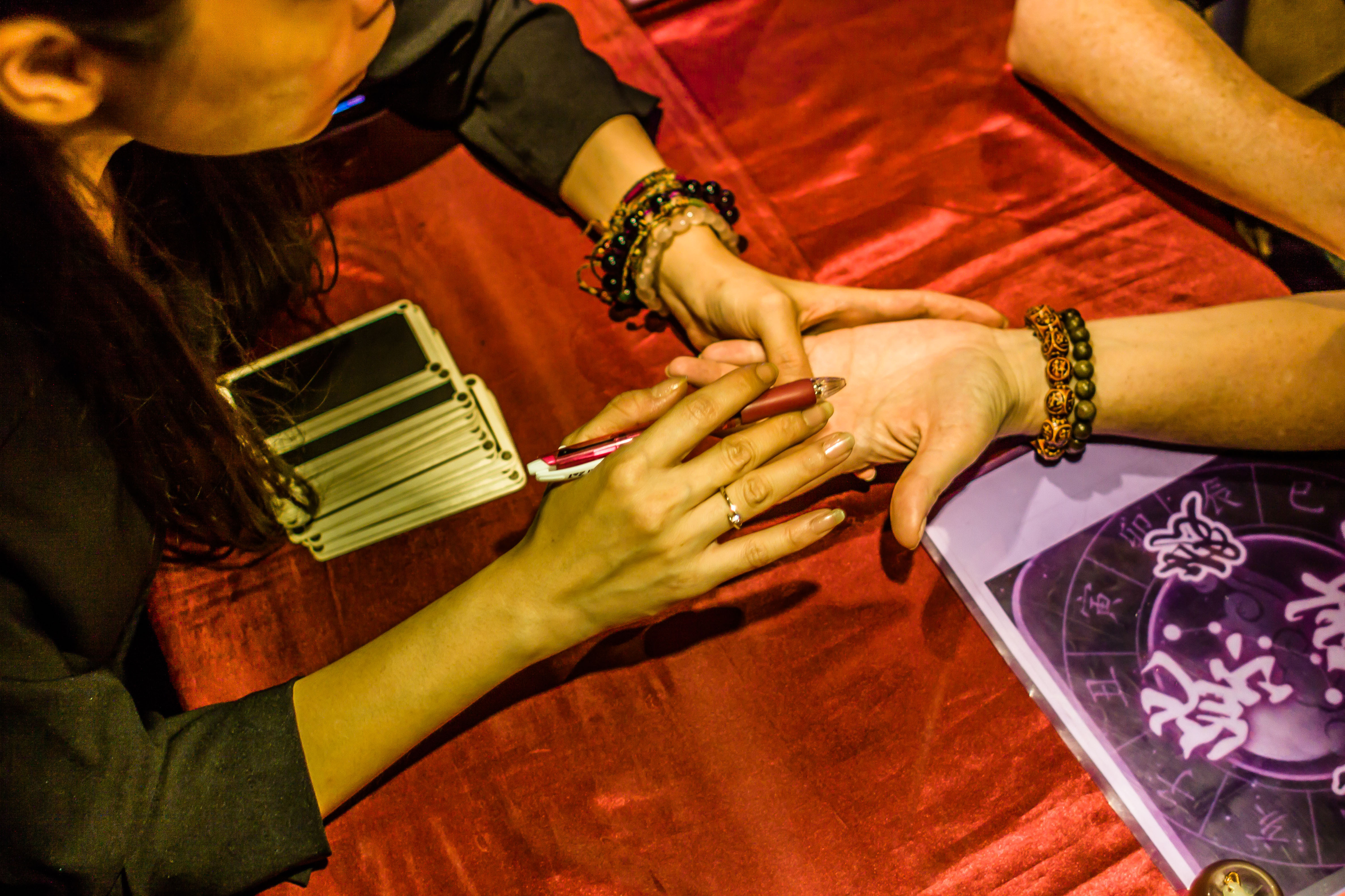 Close-up of hand lines being read by a fortune teller at Temple Street Night Market. Discover your future in Hong Kong's vibrant night market.