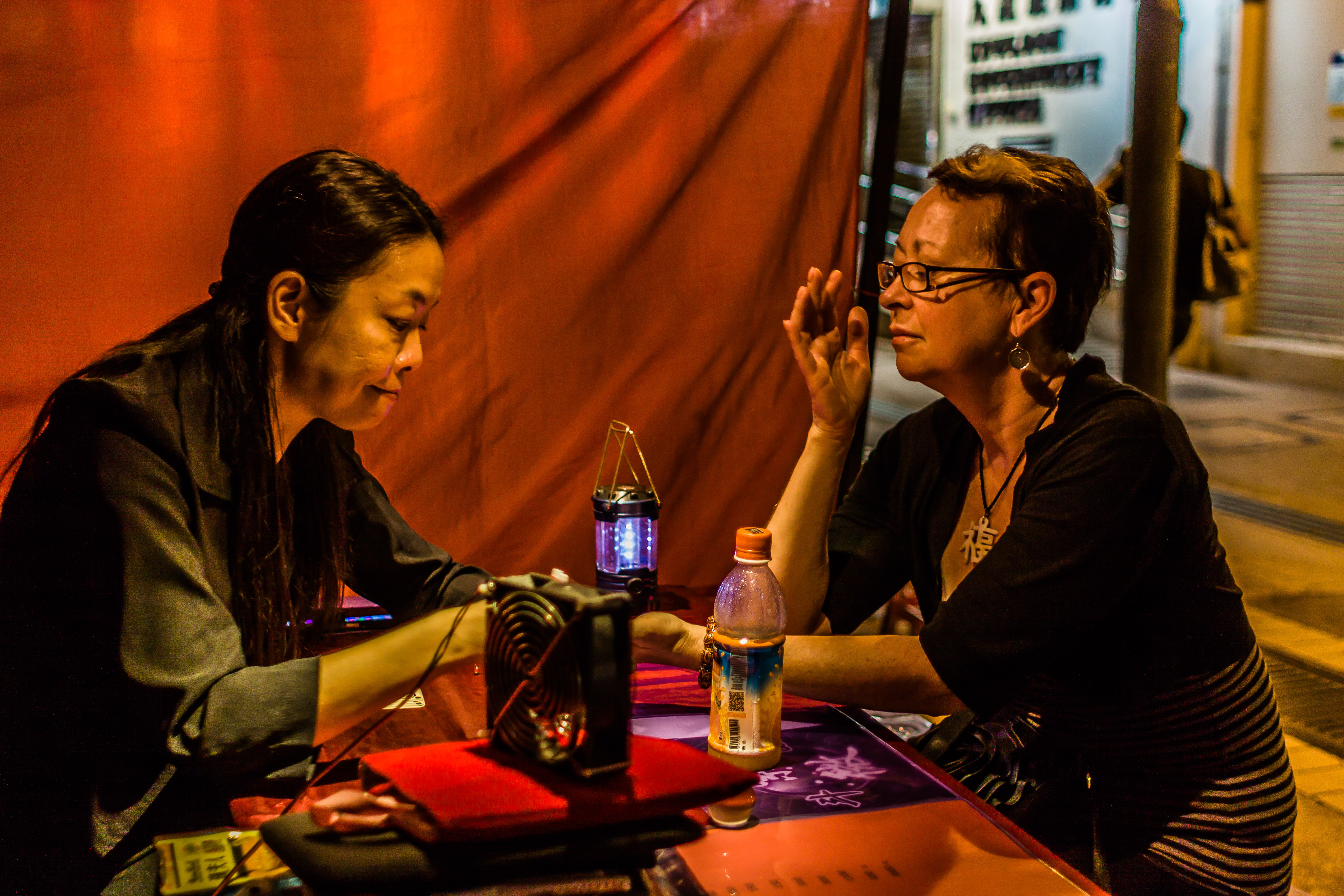 A fortune teller reading palms at Temple Street Night Market, Kowloon, Hong Kong. Experience the mystical side of Hong Kong.