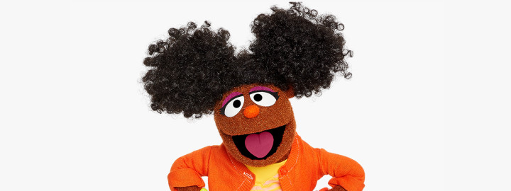 Gabrielle Sesame Street purple Muppet character painting on a canvas and smiling