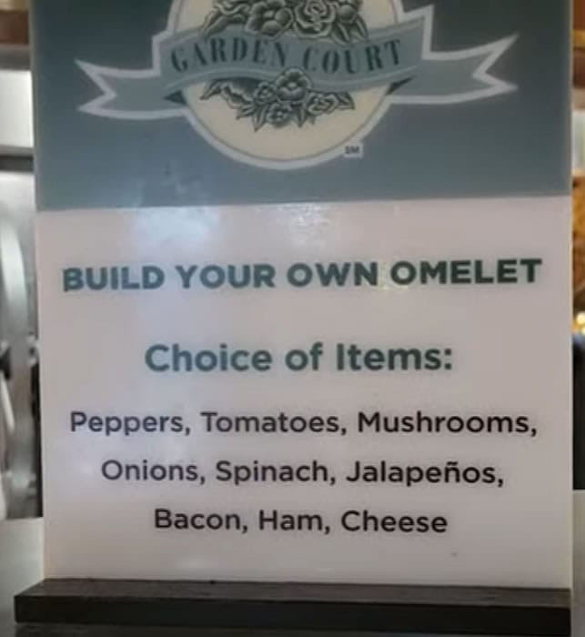 A chef preparing a custom omelet at the omelet station of Garden Court Buffet