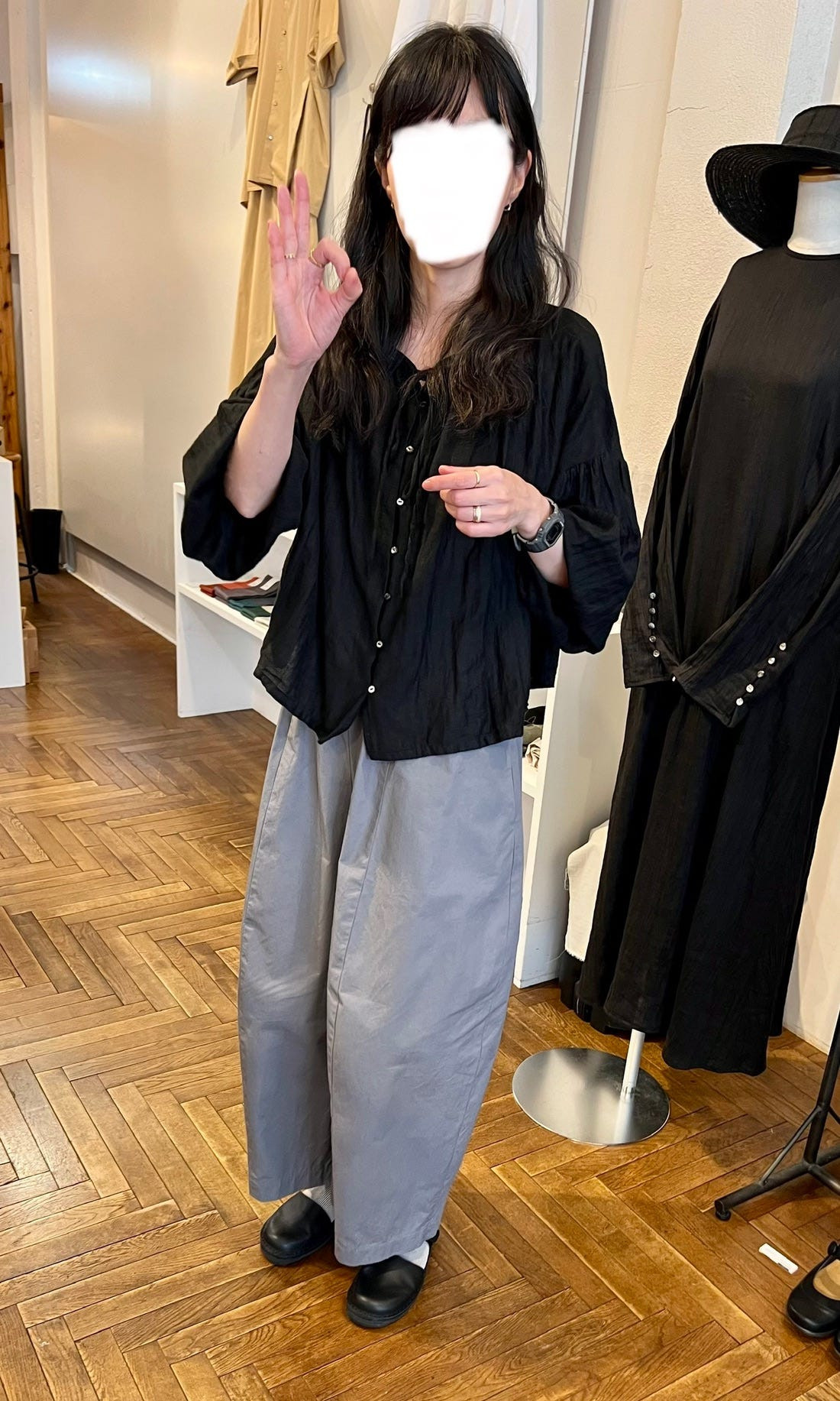 A woman in Tokyo wearing a flowing white dress and layered outerwear, showcasing the oversized and draped style popular in Japanese fashion.