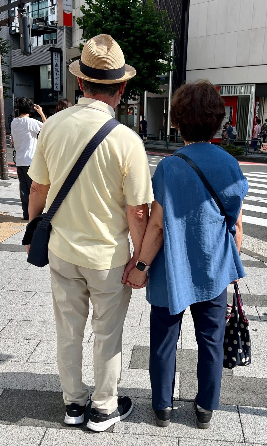 Street style photograph of a couple in matching denim jackets, demonstrating osoroi as a fashion trend among Japanese couples.