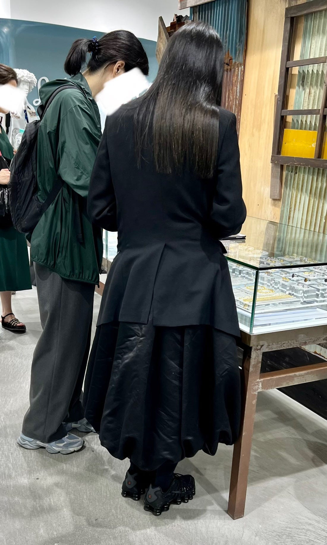 A Comme des Garçons sales associate in a striking black and white ensemble, showcasing the brand's avant-garde aesthetic.