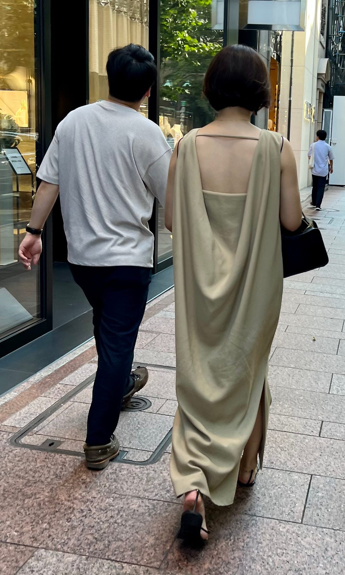 Street style image from Tokyo capturing a person in a fashionable long dress and sandals, demonstrating a more relaxed approach to modesty in the city.