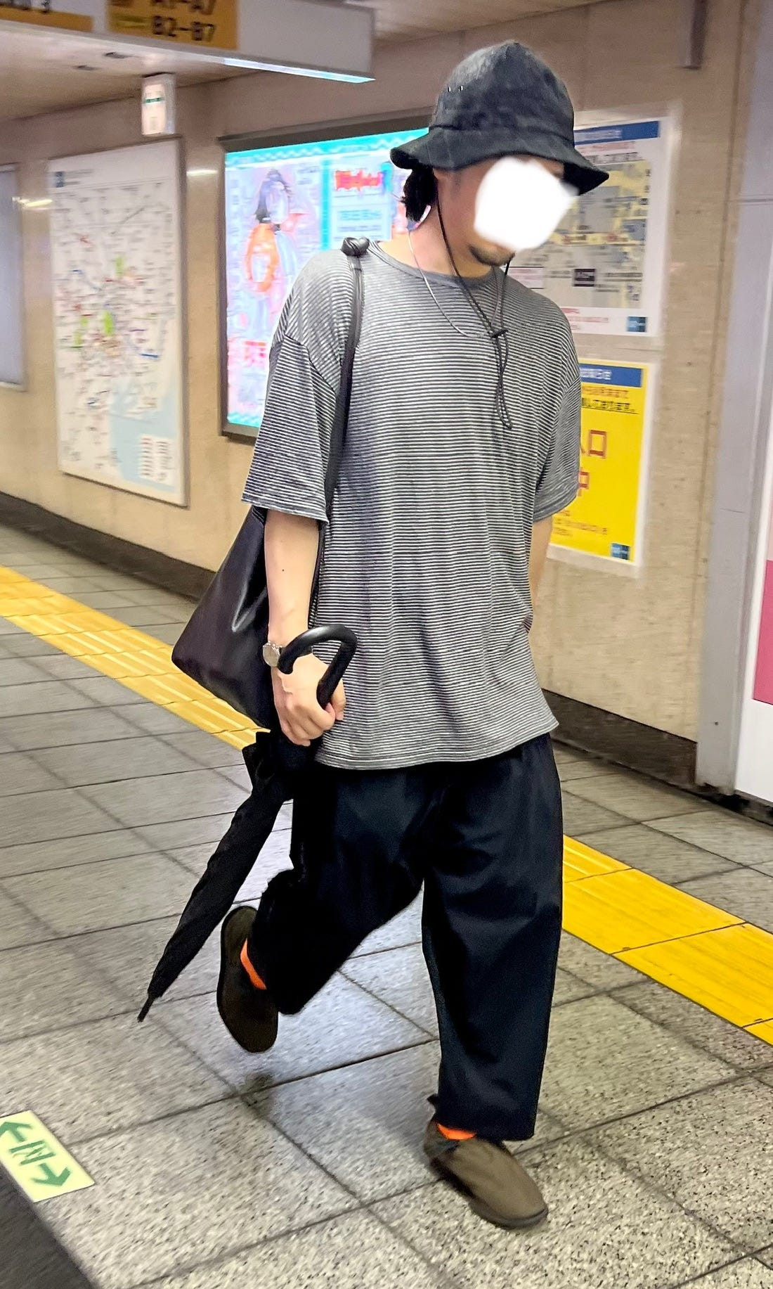 Street style image of a person in a neutral-toned, minimalist outfit, reflecting the understated elegance often seen in Japanese fashion.