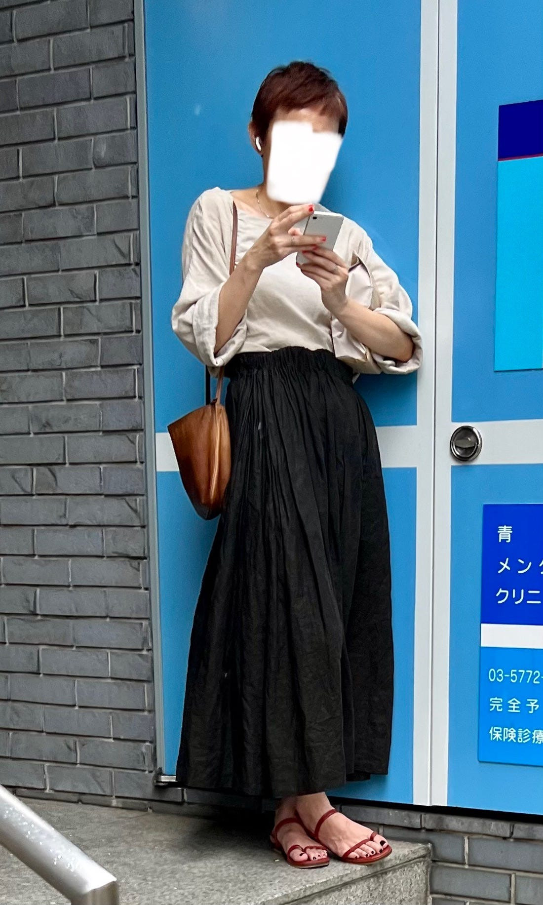 Street style photograph of a person in a layered outfit with a beret, showcasing accessorizing in Japanese street fashion.