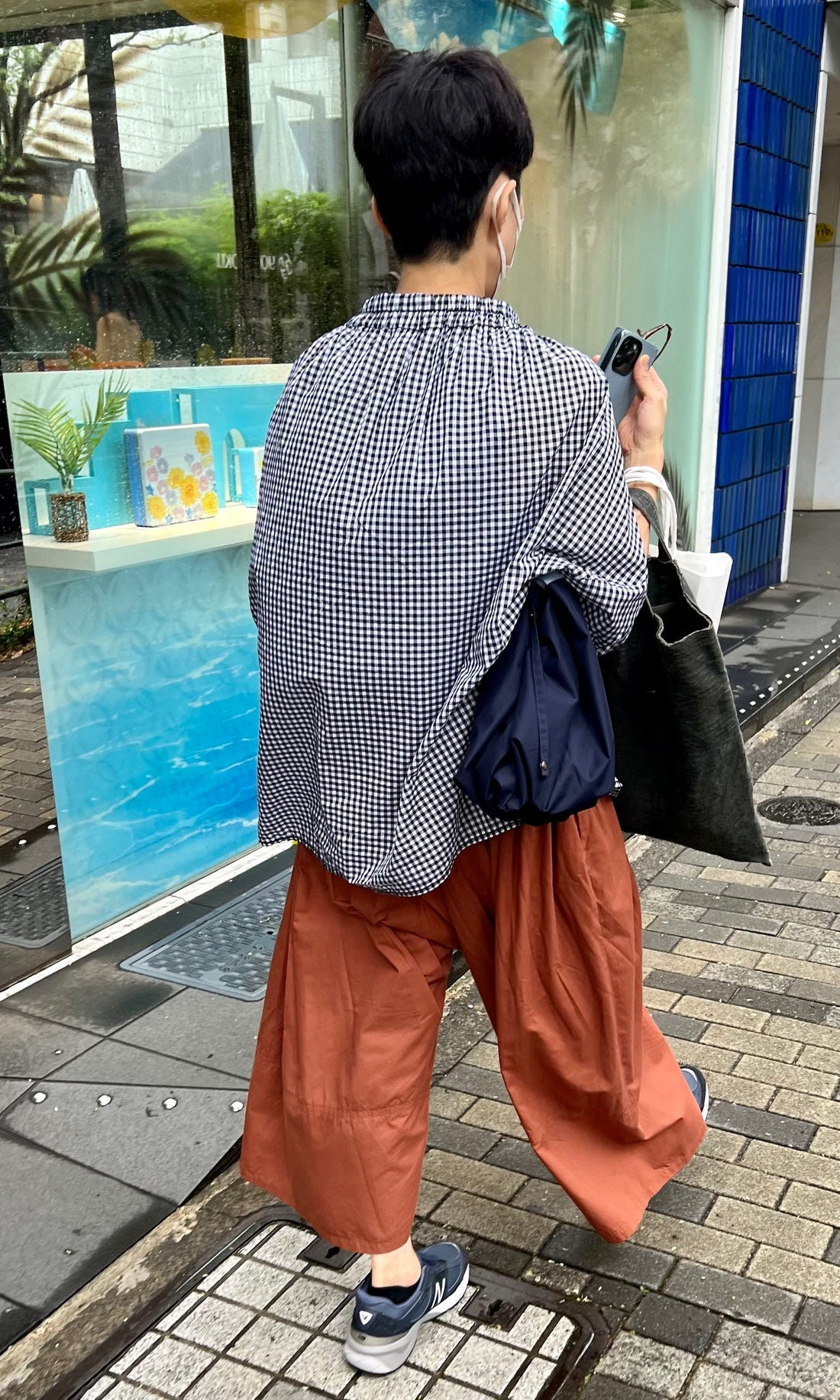Street style photograph of a person wearing a large, textured coat and wide pants, demonstrating the Japanese preference for voluminous shapes.