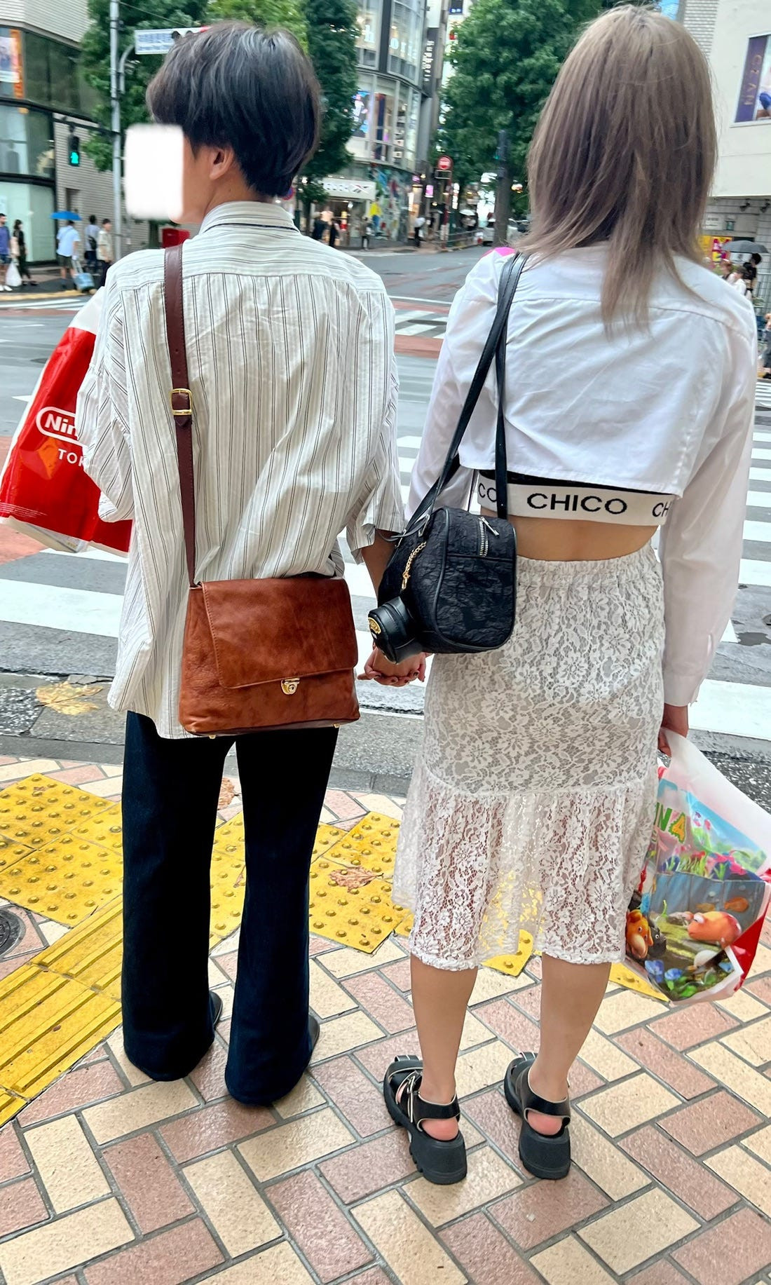 Street fashion image of a couple in similar casual outfits, showcasing the everyday application of osoroi for Japanese couples.