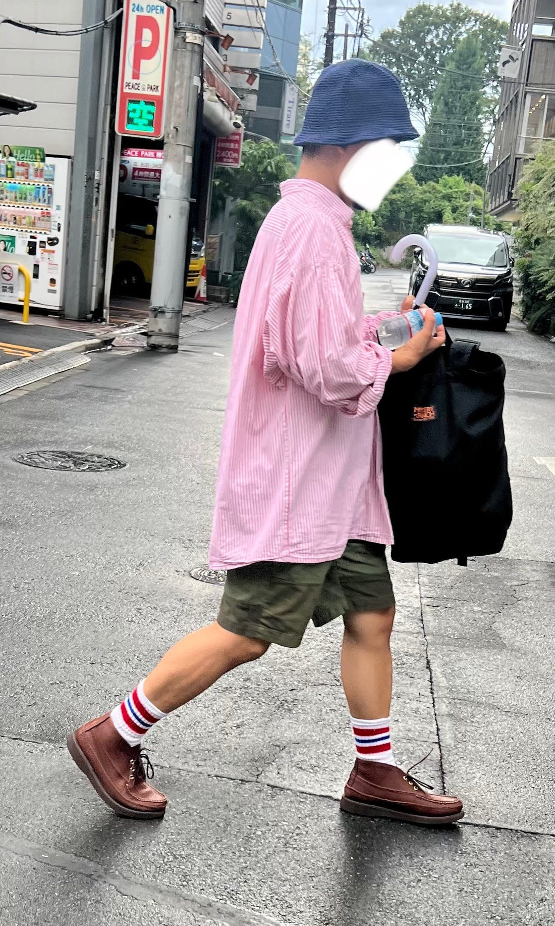 Street fashion photograph of a person in a vibrant patterned dress and hat, illustrating the use of bold prints in Japanese street style.