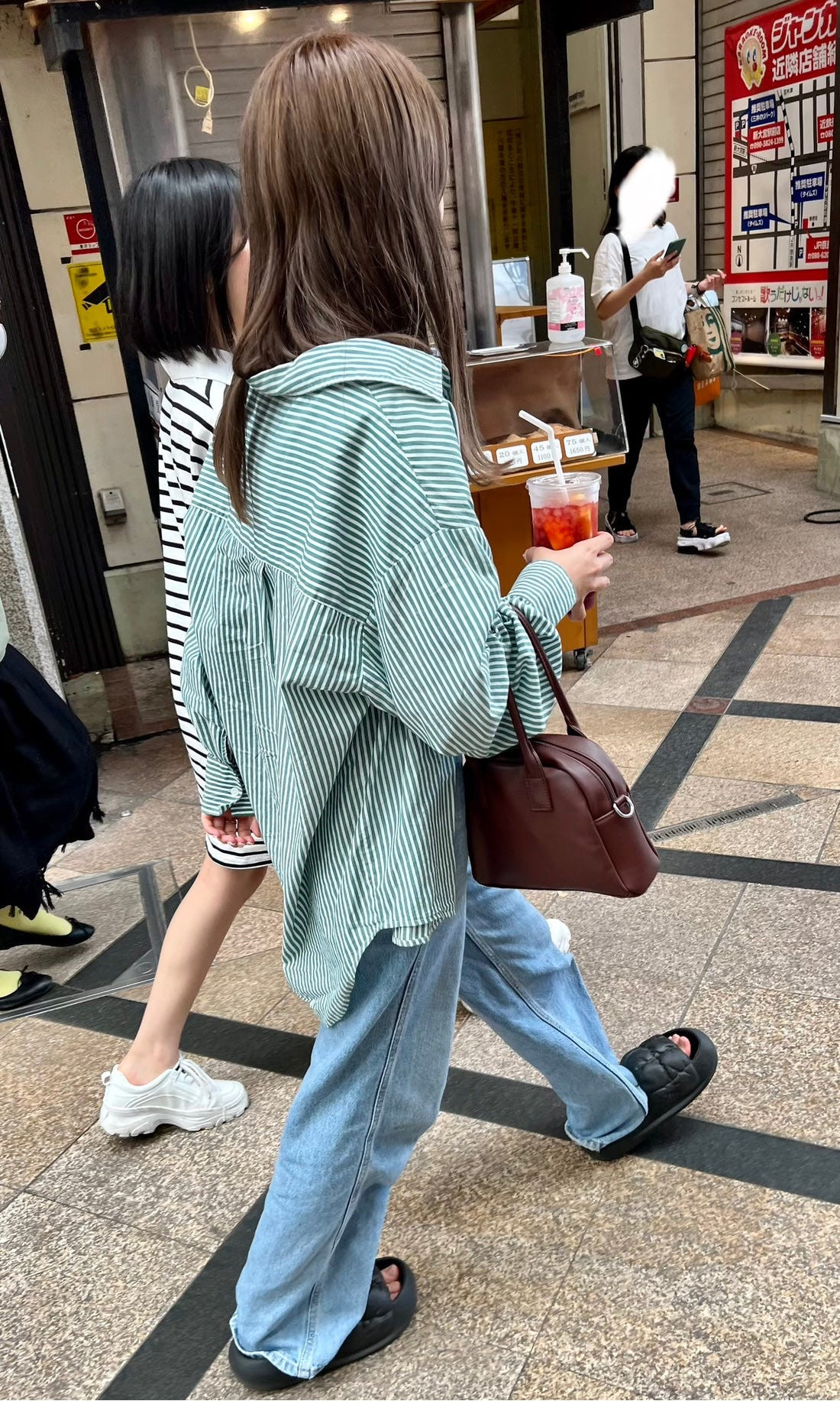 Osaka street style featuring a person in a long coat and scarf, illustrating the layered and accessorized approach to Japanese fashion.
