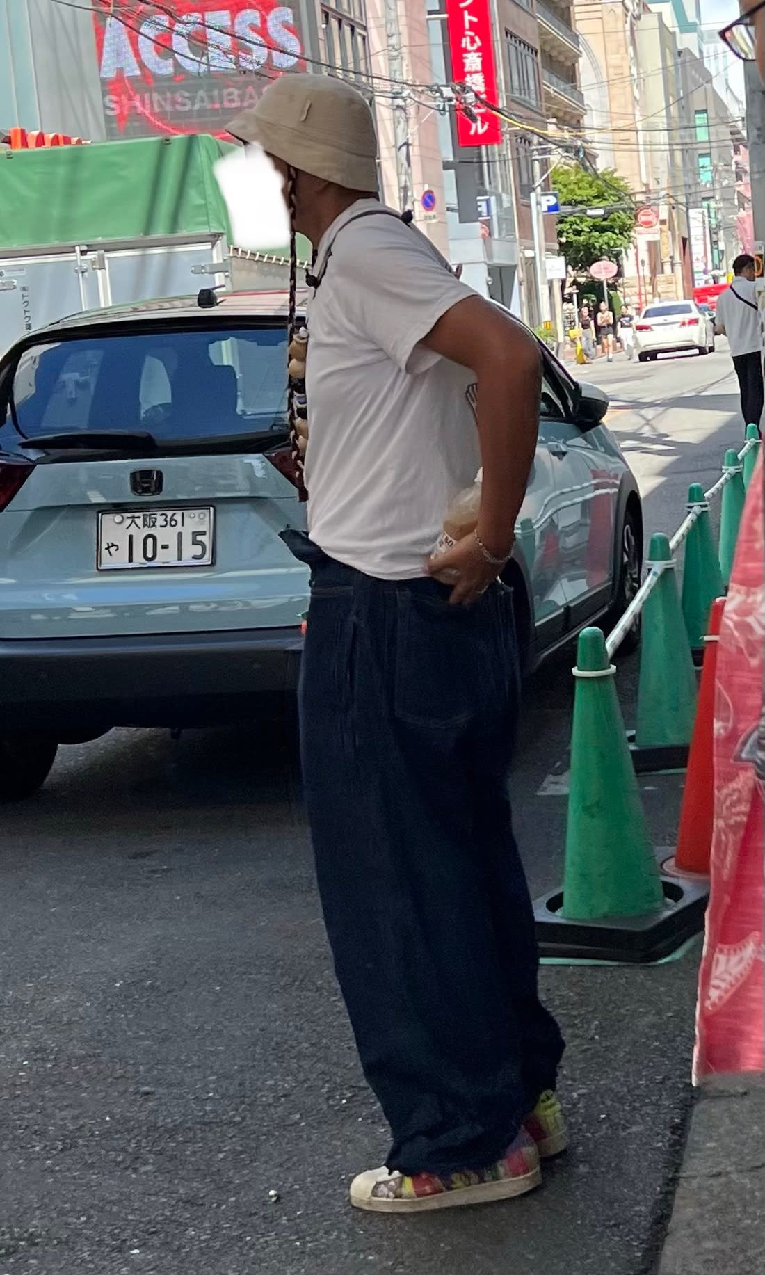 Street style photograph of a person in a sporty yet fashionable outfit, demonstrating the athleisure trend in Japanese street fashion.