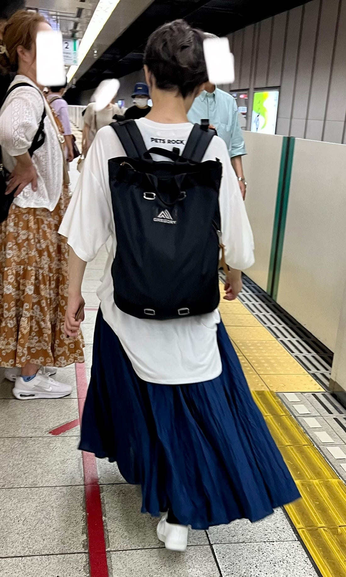 Street style image of a person in an oversized blazer and skirt ensemble, emphasizing the trend of mixing formal and casual wear in Japan.