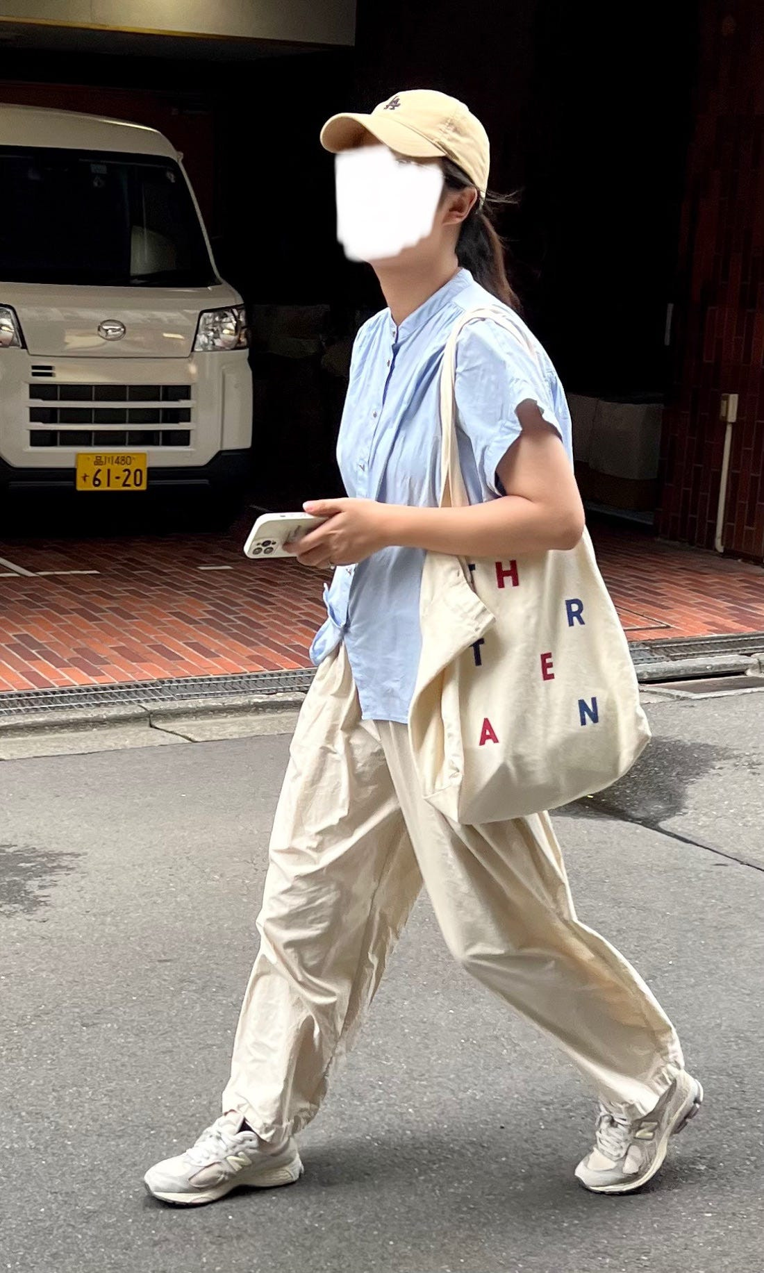 Street style photograph featuring a woman in a long shirt dress and leggings, showcasing a modest and layered Japanese fashion style.
