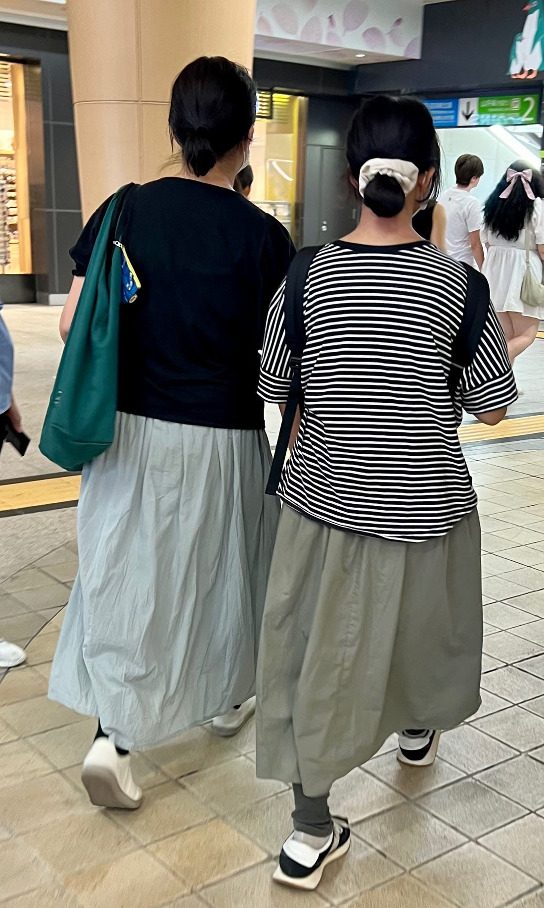 Close-up street style shot of UV protection arm sleeves, highlighting a practical accessory in Japanese summer fashion for sun protection.