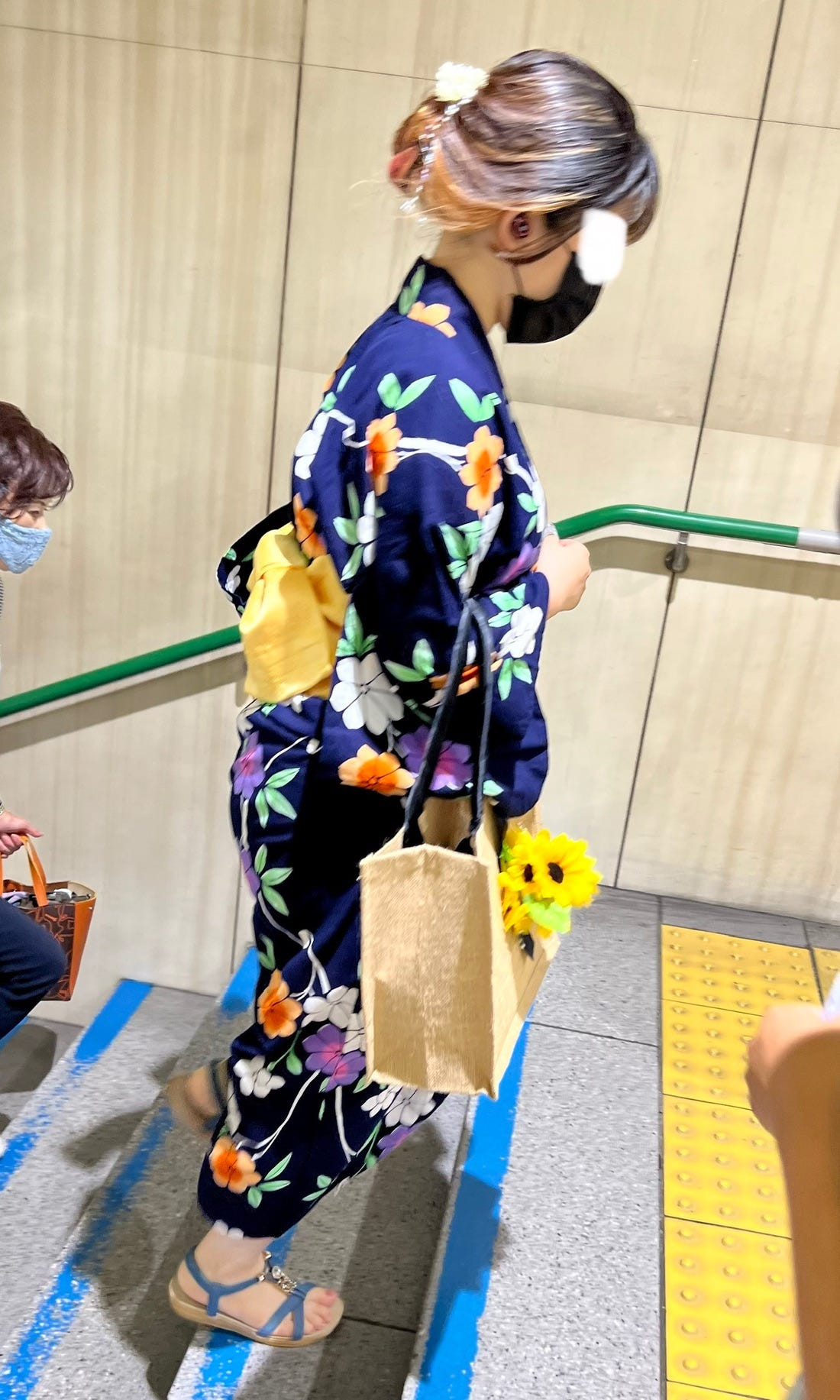 Osaka street fashion featuring a woman in a yukata on a city street, demonstrating the integration of traditional wear into contemporary Japanese life.