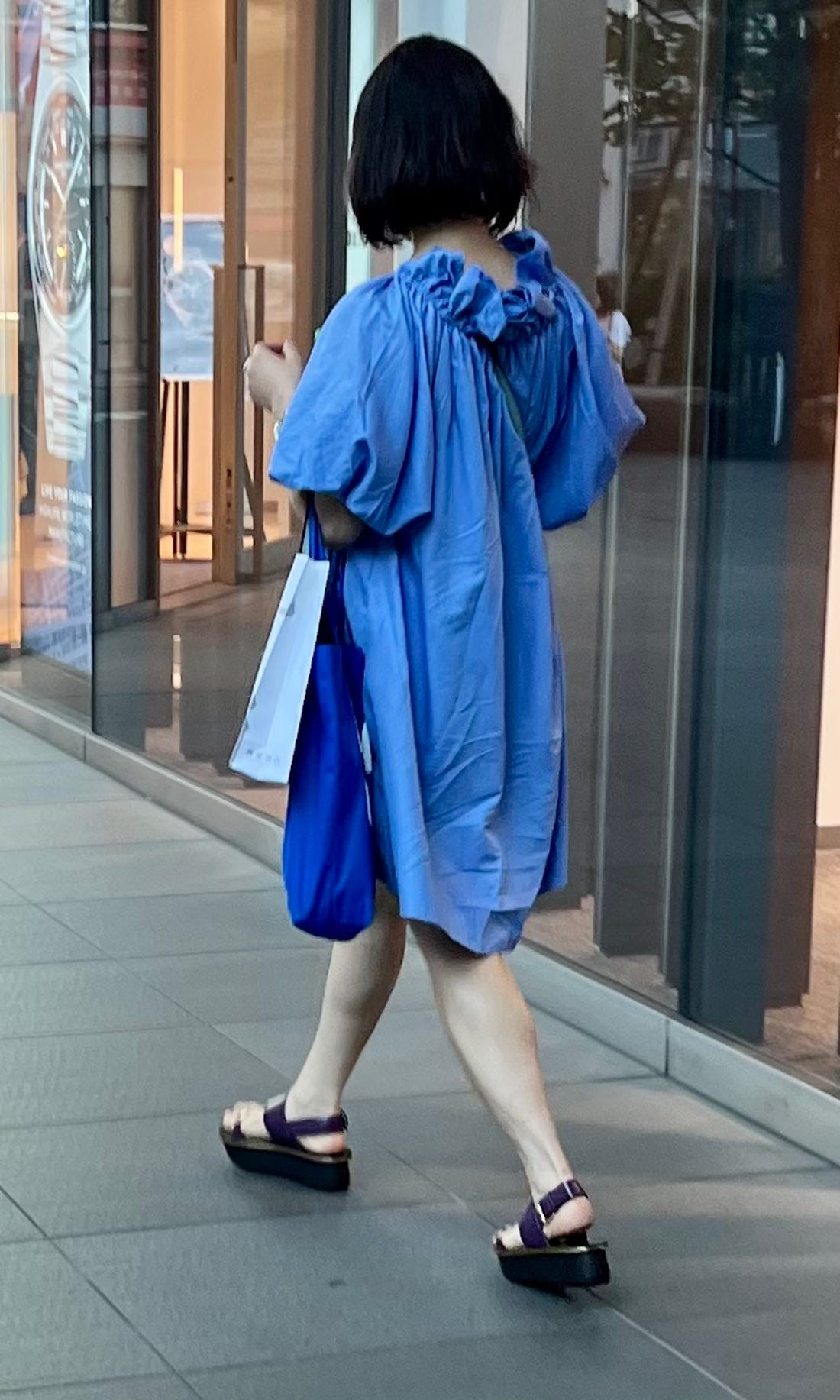 A woman in Osaka sporting a long, oversized shirt dress and sneakers, exemplifying the comfortable and stylish oversized trend in Japan.