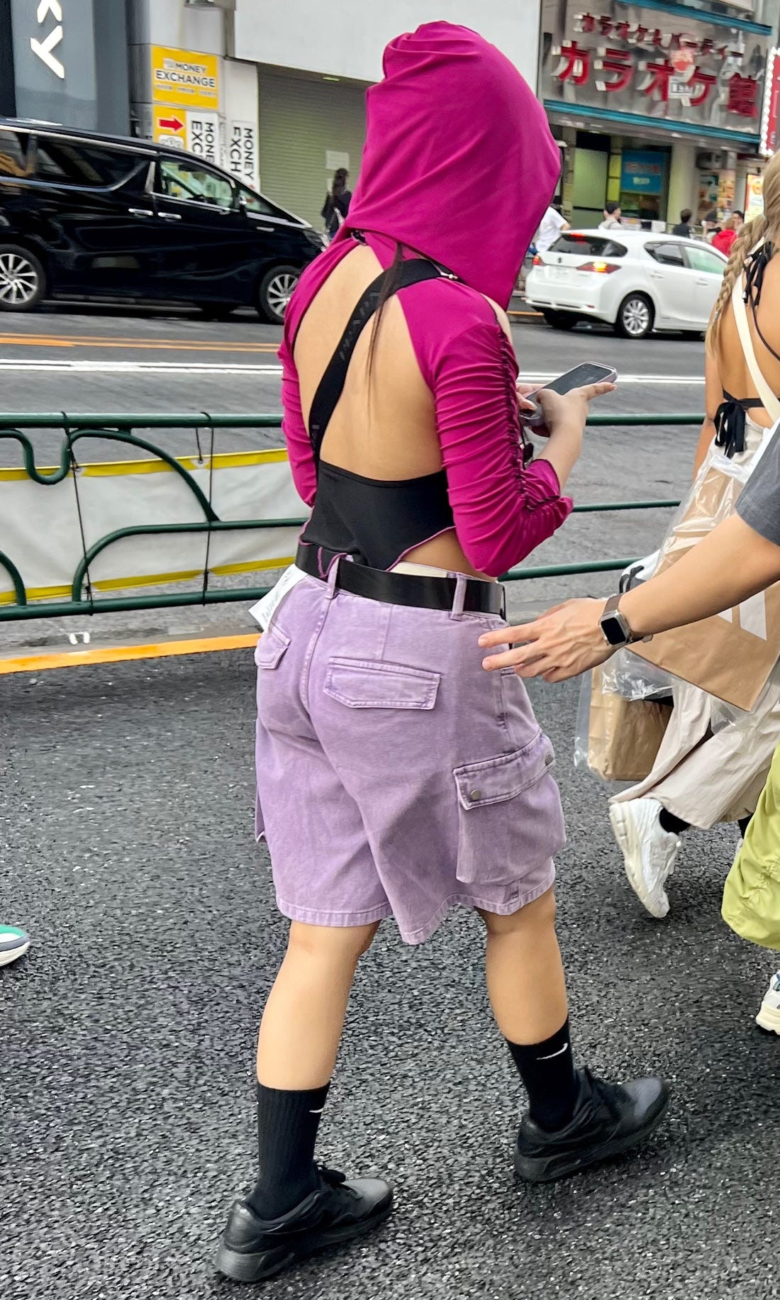 Tokyo street style photograph of a woman in a stylish long skirt and top, showcasing a balance between modesty and fashion-forward style.