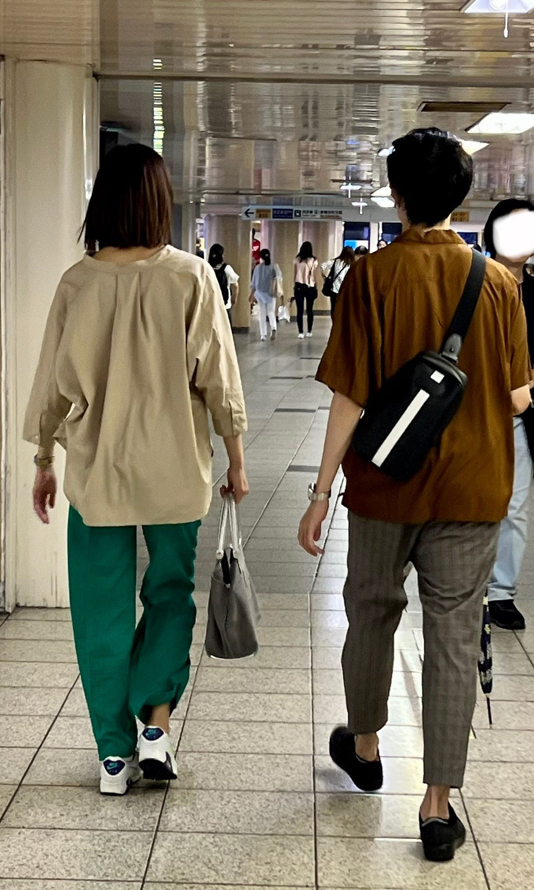 Street style photograph of a group of friends in coordinated pastel outfits, highlighting the use of color palettes in osoroi Japanese fashion.