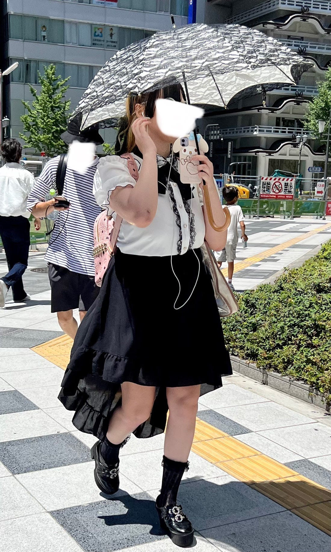 Tokyo street style image featuring a woman in a platform boots and mini skirt, reminiscent of gyaru fashion trends.