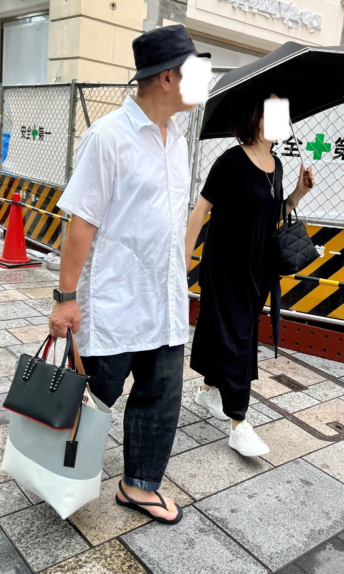 A person in Kyoto wearing an oversized black jacket and wide-leg pants, reflecting the influence of Japanese designers on silhouette.