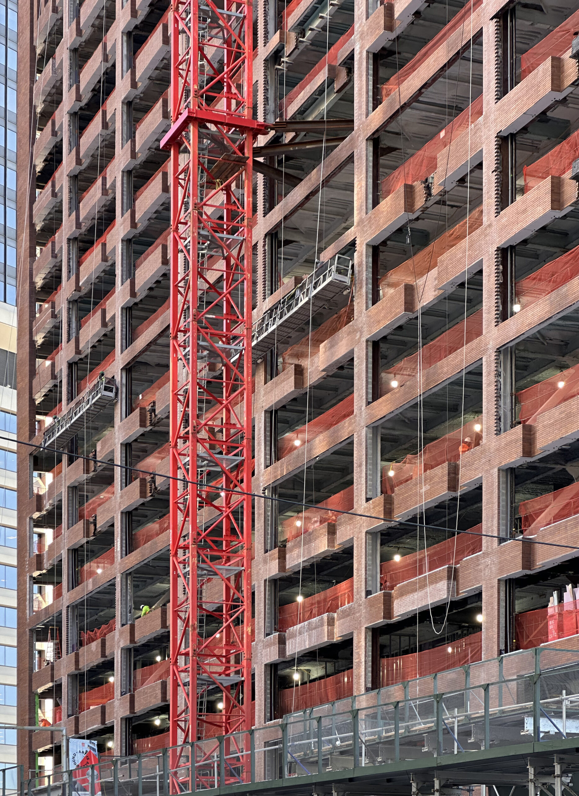 Wide shot capturing the full height of 25 Water Street as construction reaches the topping out phase in NYC.