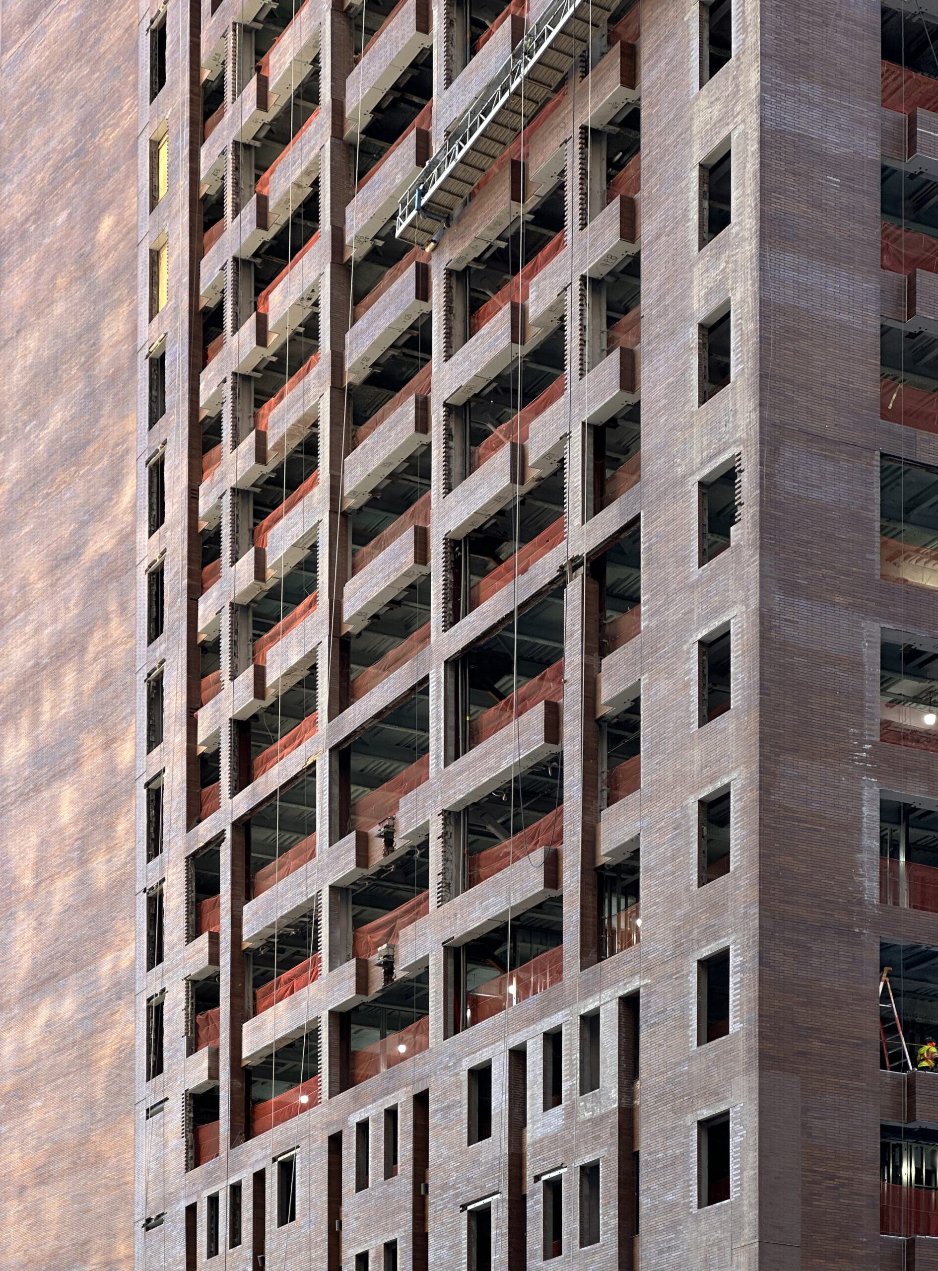The evolving facade of 25 Water Street, contrasting the old brick with the new window grid in the Financial District.