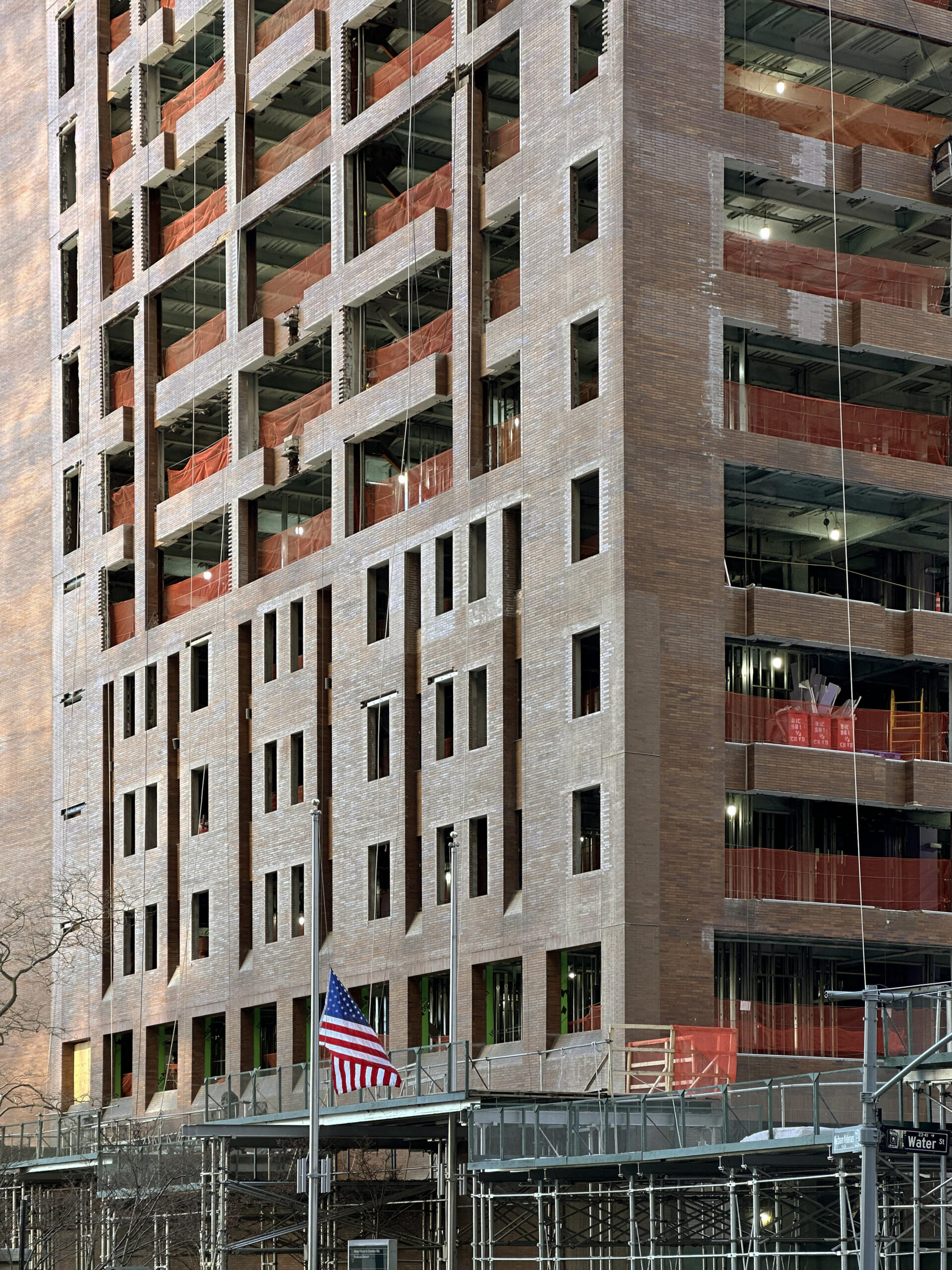 Looking up at the towering 25 Water Street, emphasizing its height and presence on Water Street in New York City.