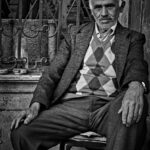 A black and white street photograph in Istanbul, showcasing a man walking through a bustling street scene, capturing a sense of motion and urban life.