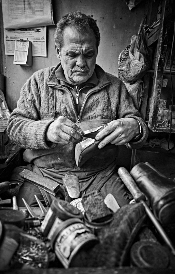 A street photography shot taken on Ilford Delta 400 film, depicting a photographer in action, capturing a portrait in an urban environment, emphasizing the process of street portraiture.
